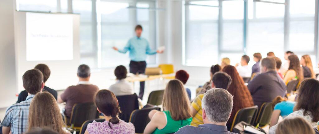 A person putting on a presentation in front of a large group of people