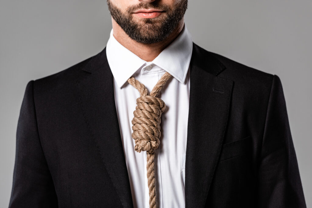Close up of a man dressed in a business suit with a noose as a tie